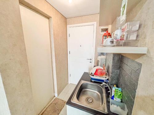 a small kitchen with a sink and a door at Barsa City Babarsari 266 in Yogyakarta