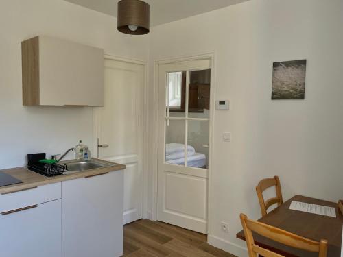 une cuisine avec un évier, une table et une fenêtre dans l'établissement Petit gîte - Ty Bihan, à Querrien