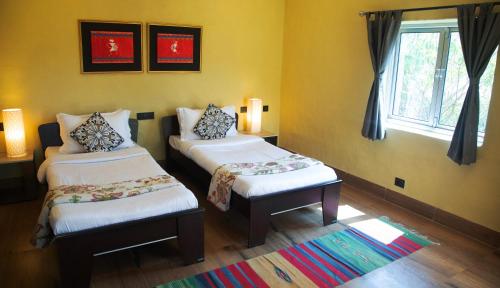 a room with two twin beds and a window at Eco Adventure Resorts Khhairabera in Bāghmundi