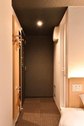 a room with a bed and a door to a hallway at FL Hotel Asakusa in Tokyo