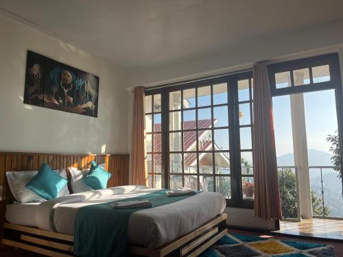 a bedroom with a large bed and a large window at Bahar Retreat And Spa , Gangtok in Gangtok