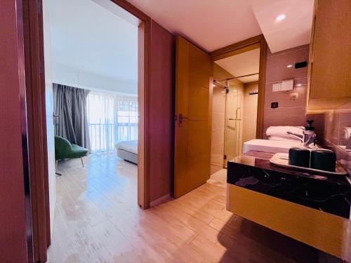 a hotel room with a bathroom with a bed and a sink at Poly Central Plaza By Boli at Sanya City Center#Near Joy City in Sanya