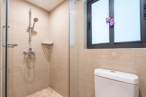a bathroom with a shower with a toilet and a window at Poly Central Plaza By Boli at Sanya City Center#Near Joy City in Sanya