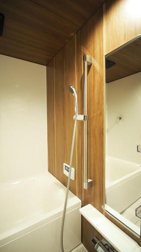 a shower in a bathroom with a tub and a sink at ゲストハウスとわ in Kanazawa