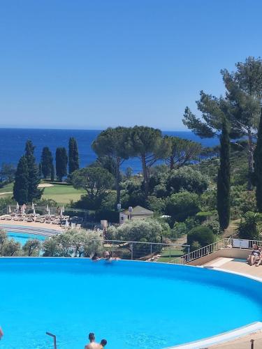 une grande piscine bleue avec vue sur l'océan dans l'établissement Village Vacances CAP ESTEREL , AGAY , T2 climatisé vue mer panoramique - accès de plain-pied au calme rare sur le site - Piscines et parking couvert inclus, à Saint-Raphaël