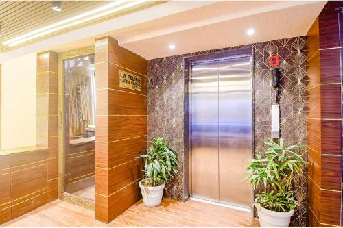 a elevator lobby with two potted plants in front of a door at FabHotel Lake View Topsia in Kolkata