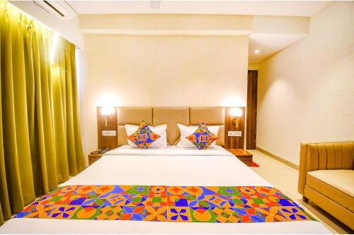a bedroom with a large bed with a colorful blanket at FabHotel Lake View Topsia in Kolkata
