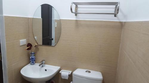 a bathroom with a toilet and a sink and a mirror at The Courtyards Goshen in Baguio