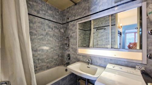 une salle de bain avec un lavabo, une baignoire et un miroir dans l'établissement Résidence Betelgeuse - Appartement confortable · Proche des pistes et des commerces · Balcon MAE-7376, à Flaine