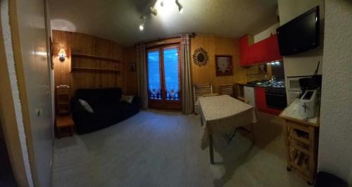 Il dispose d'une cuisine et d'un salon avec un canapé et une table. dans l'établissement Résidence La Croix Du Sud - Studio cabine 4 personnes 2 exposé nord MAE-7924, à Valloire