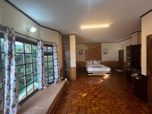 a bedroom with a bed and a large window at Bahar Retreat And Spa , Gangtok in Gangtok