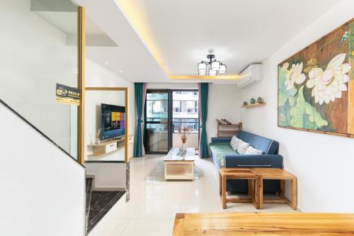 a living room with a couch and a tv at Poly Central Plaza By Boli at Sanya City Center#Near Joy City in Sanya