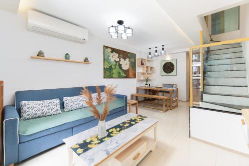 a living room with a blue couch and a table at Poly Central Plaza By Boli at Sanya City Center#Near Joy City in Sanya