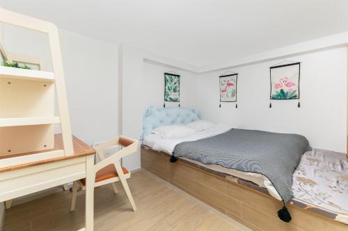 a bedroom with a bed and a desk at Poly Central Plaza By Boli at Sanya City Center#Near Joy City in Sanya