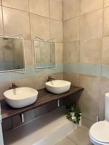 a bathroom with two sinks and a toilet at Palms Beach Apartment- Seaviews in Port Alfred