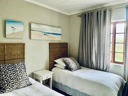 a hotel room with two beds and a window at Palms Beach Apartment- Seaviews in Port Alfred