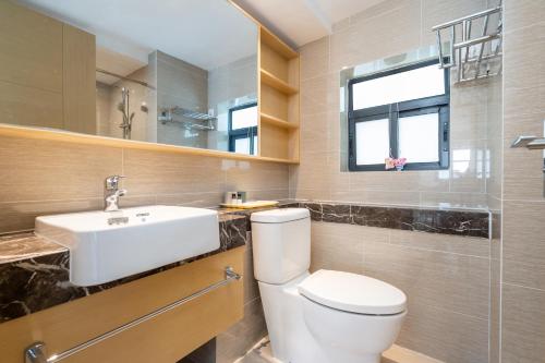 a bathroom with a toilet and a sink and a window at Poly Central Plaza By Boli at Sanya City Center#Near Joy City in Sanya
