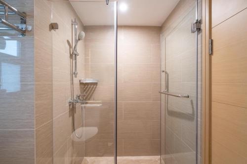 a shower with a glass door in a bathroom at Poly Central Plaza By Boli at Sanya City Center#Near Joy City in Sanya