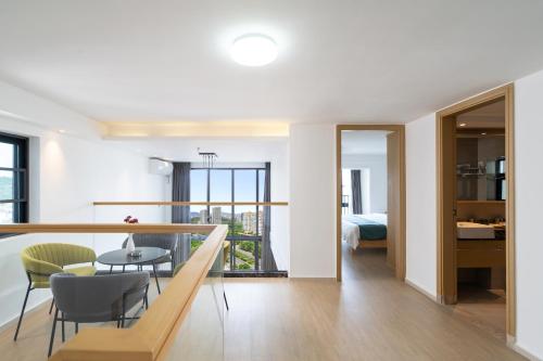 a room with a balcony with a table and chairs at Poly Central Plaza By Boli at Sanya City Center#Near Joy City in Sanya