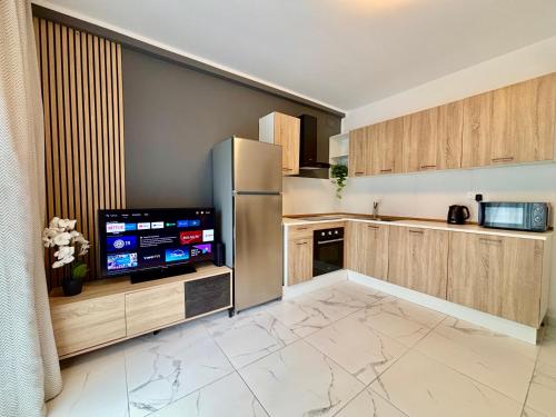 a kitchen with wooden cabinets and a refrigerator at Steps to Sea - Affordable Luxury Living in St. Paul's Bay