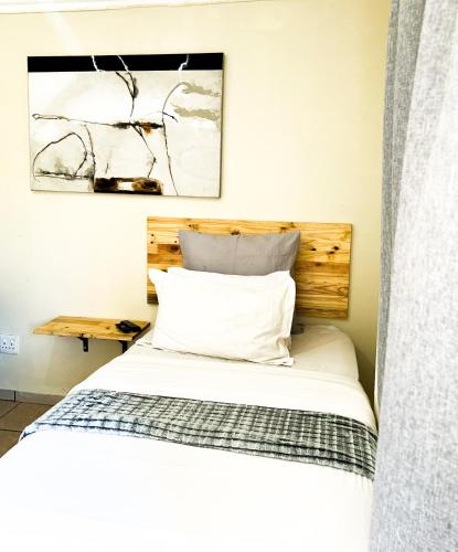 Un dormitorio con una cama con cabecero de madera. en AK Secunda Accommodation, en Secunda