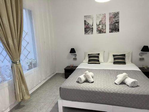 a bedroom with a bed with towels on it at Sagma Beach Rooms in Perissa