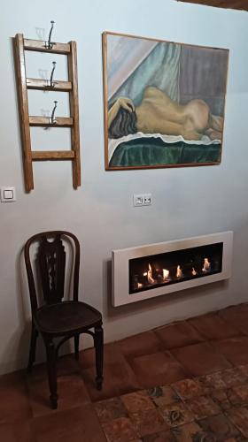 a room with a fireplace with a painting and a chair at Casa rural en Buendía -la Galera con 4 dormitorios in Buendía