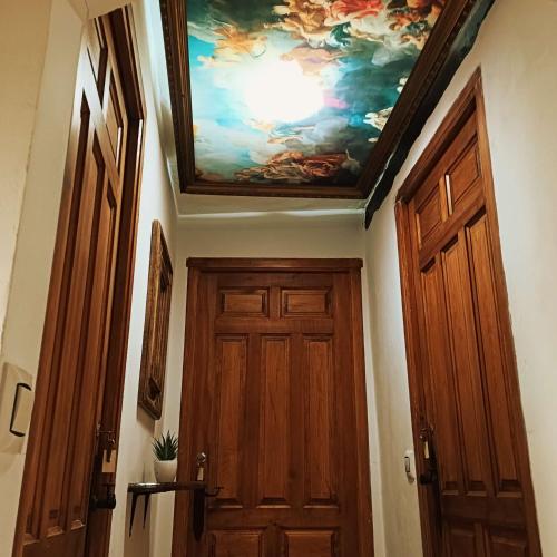 a hallway with a ceiling with a painting above a door at Casa rural en Buendía -la Galera con 4 dormitorios in Buendía