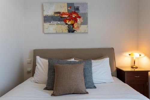a bedroom with a bed and a painting on the wall at Villa Kallisto With Private Pool And Stunning Sea Views in Vassilias