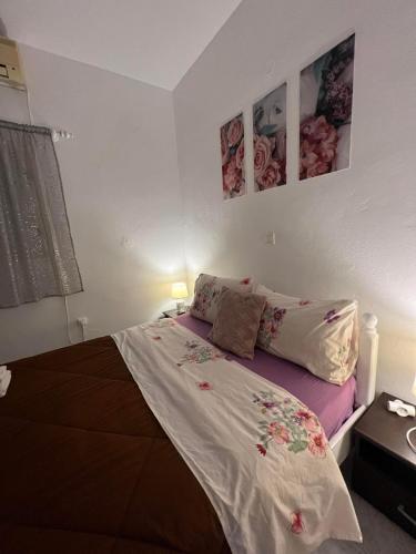 a bed in a bedroom with two pictures on the wall at Sagma Beach Rooms in Perissa