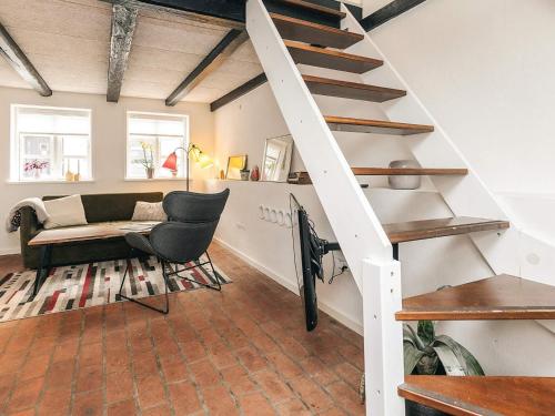a living room with a staircase and a couch at 4 star holiday home in Aalborg in Aalborg