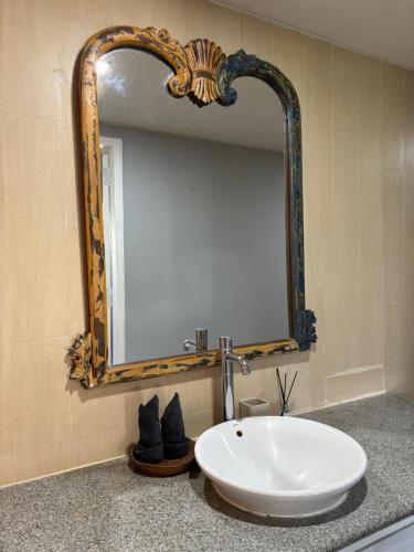 a bathroom with a white sink and a mirror at villa Angin in Munggu