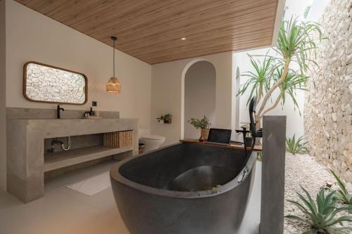a bathroom with a large tub and a sink at The Cendana Villa Yogyakarta in Bedoyo