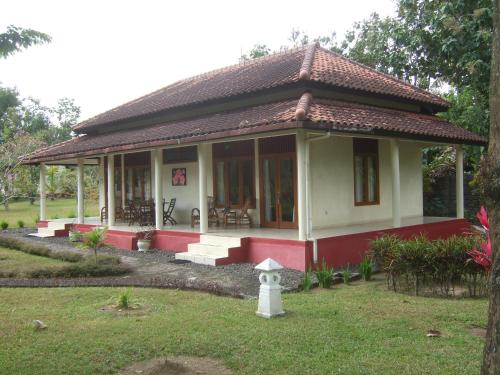 a small house with a red and white at Guesthouse Rumah Senang in Kalibaru