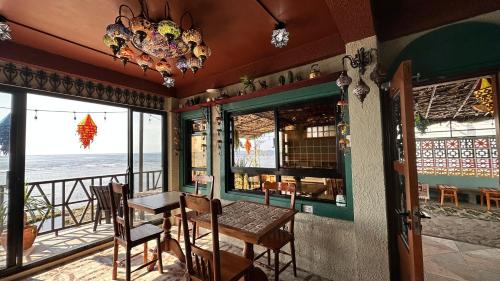 a dining room with a table and chairs and the ocean at REEF HOUSE BACNOTAN White sand beach front with Private Swimming pool in Bacnotan