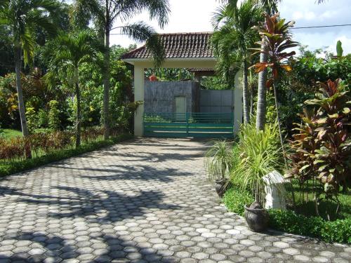 a walkway leading to a house with a bench at Guesthouse Rumah Senang in Kalibaru