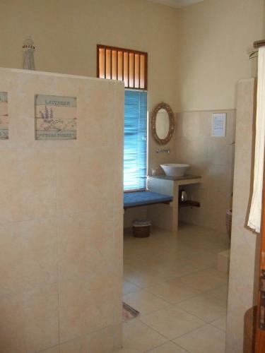 a bathroom with a sink and a mirror at Guesthouse Rumah Senang in Kalibaru
