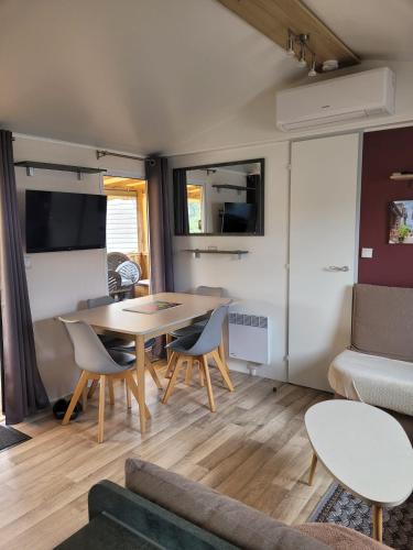 un salon avec une table, des chaises et un canapé dans l'établissement Vue bassin Arcachon mobil-home top 8 personnes by Vayny, à Lège-Cap-Ferret