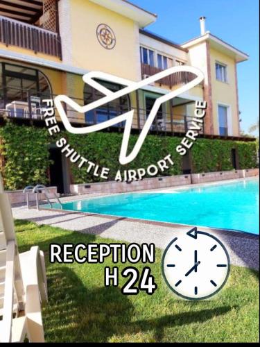 un panneau indiquant un hôtel avec une horloge à côté d'une piscine dans l'établissement Residence Villa Rosa dei Venti, à Cinisi