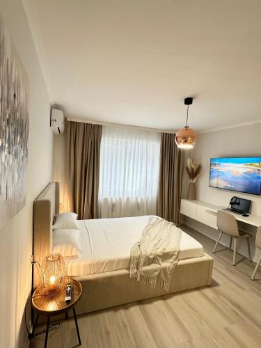 a bedroom with a large bed and a desk at Monique's apartament 2 in Timişoara