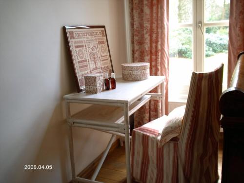 une table dans une pièce avec un panneau et une fenêtre dans l'établissement Domaine Pansu, à La Celle-sous-Gouzon