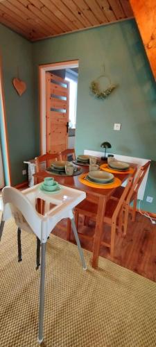 a dining room with a wooden table and chairs at Żurawisko - Domki wśród natury in Jesiona