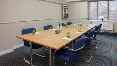 a conference room with a long table and blue chairs at Holiday Inn Washington by IHG in Washington