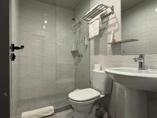 a bathroom with a shower and a toilet and a sink at Afsona in Qarshi