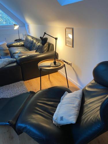 a living room with a couch and a table with a lamp at Harzpur Lodge - Pure Entspannung in purer Natur in Hahnenklee-Bockswiese