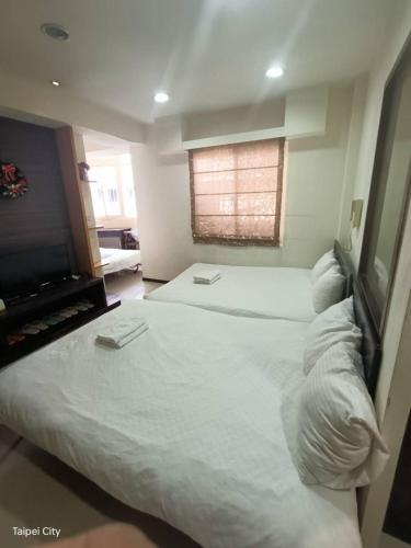a bedroom with two large beds and a television at Ximen NIANIA in Taipei