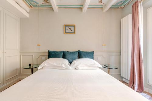 博洛尼亚Deluxe Suite Fine Art Historic Centre的卧室里有一张白色的大床，配有蓝色的枕头