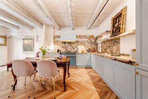 博洛尼亚Deluxe Suite Fine Art Historic Centre的房间里有一张桌子和几把椅子的厨房