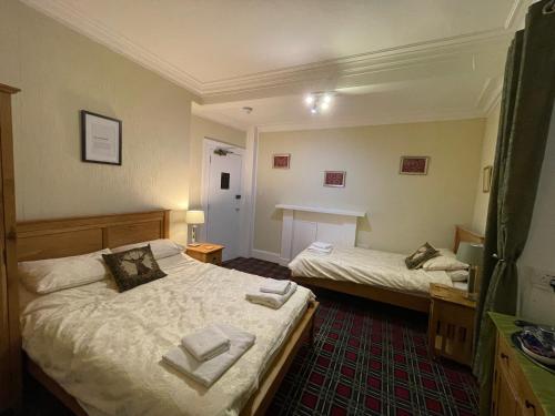 a bedroom with two beds and a table in it at Stag and Barrel in Elgin