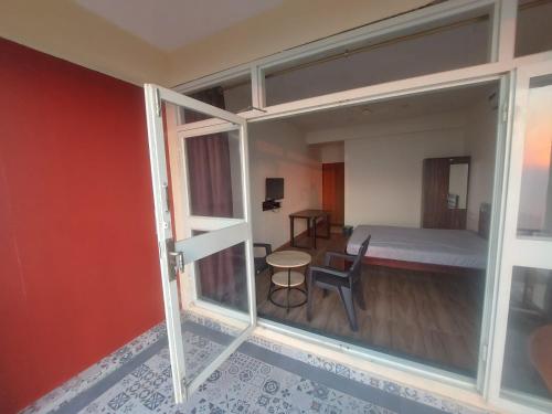 a room with a bed and a glass door at 4 Seascape in Dapoli